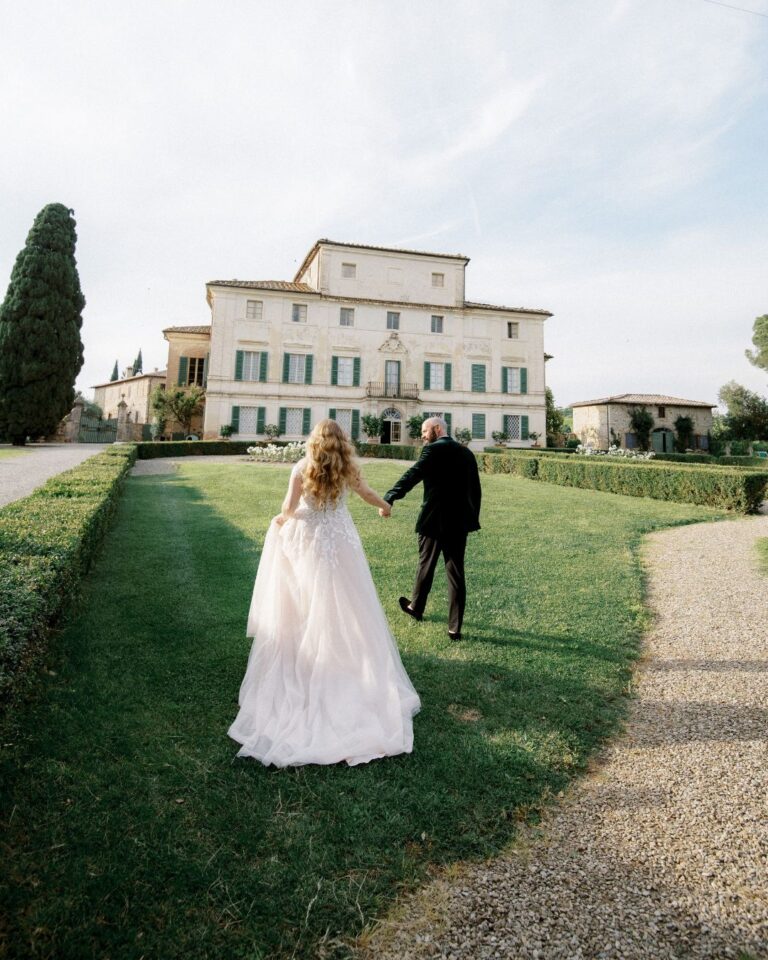 The bride and groom take a romantic stroll through the Tuscan gardens of Villa di Geggiano, photographed by Linda Nari.