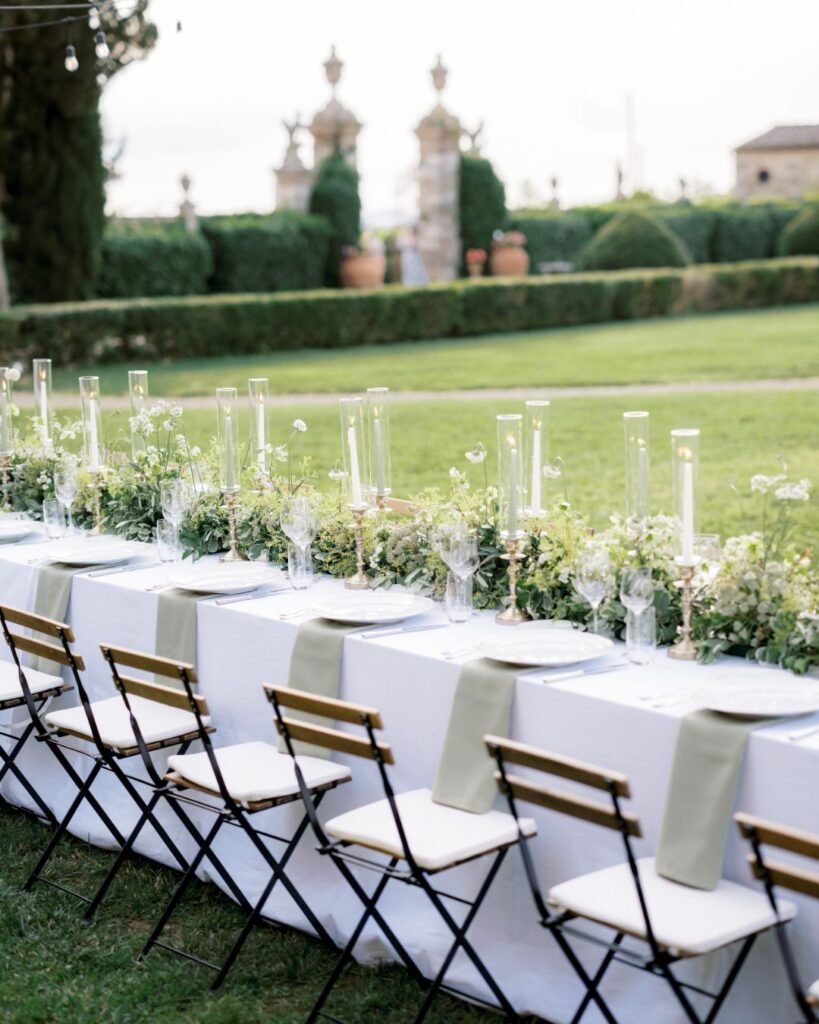 Elegant wedding dinner tables set at Villa di Geggiano, complete with romantic candles and floral arrangements, captured by Linda Nari.