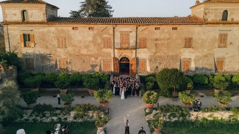 Wedding guests gathered on the steps of Villa Medicea di Lilliano, celebrating under golden Tuscan light.