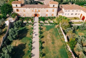 Aerial shot of Villa Medicea di Lilliano, showcasing its grand estate, lush gardens, and surrounding Tuscan vineyards.