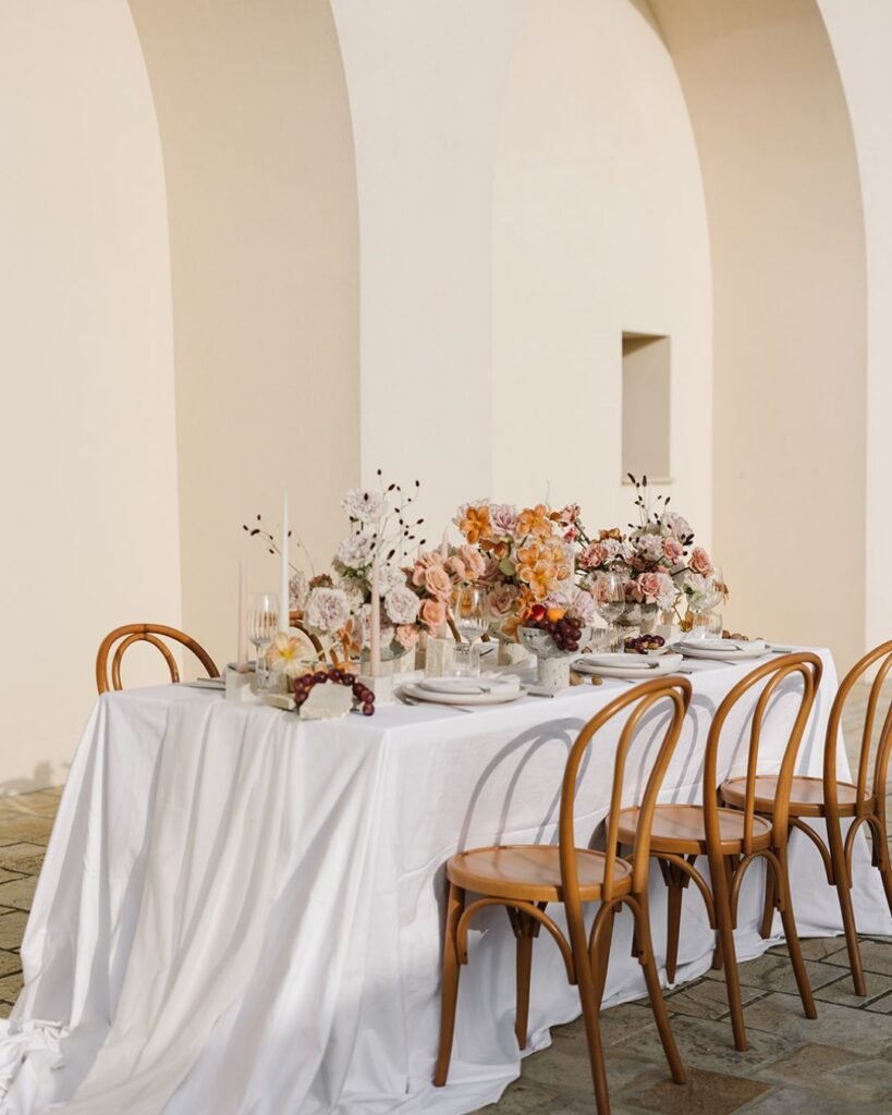 A close-up of wedding table centerpieces at Masseria Fontana di Vite, with fresh Italian greenery and neutral-toned florals.