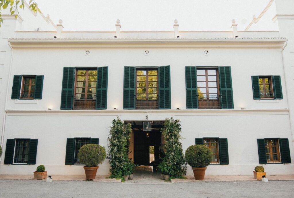 Stunning main exterior view of Masia Aldamar, a picturesque Spanish wedding venue surrounded by lush greenery.