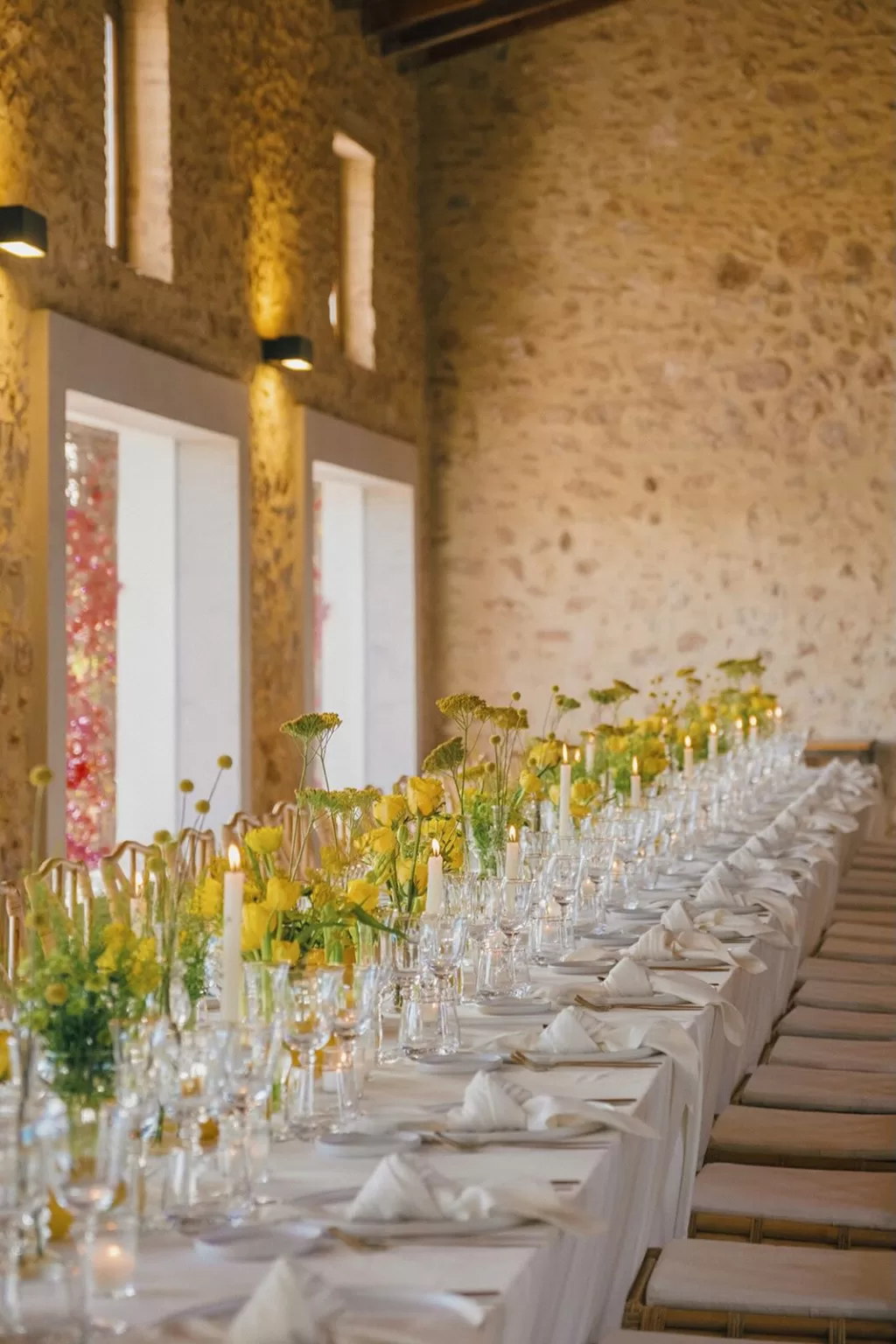 Romantic reception table setting with yellow flowers and candles at Masia Aldamar