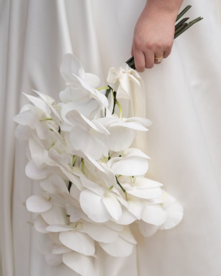 A close-up of a lush bridal bouquet filled with soft pastel blooms, captured by Bella Weddings.