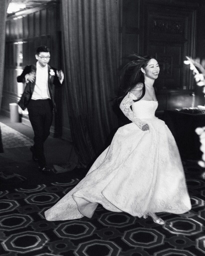 The bride lifts her wedding gown as she gracefully walks up the steps, captured by Studio Fotografico Bacci