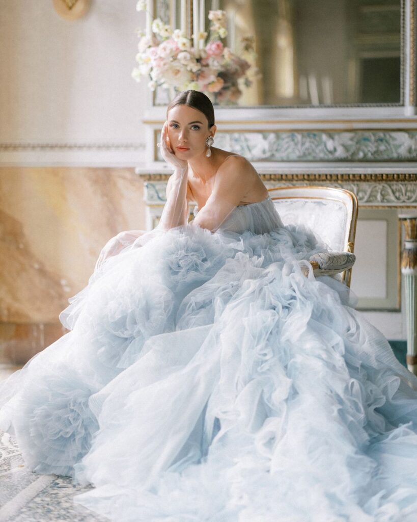 Bride gazing out of a sunlit window, lost in thought before the ceremony.