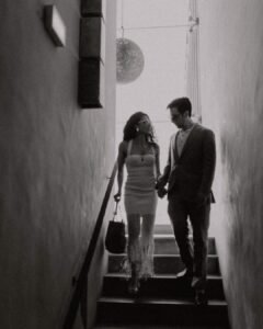 The couple walking down the modern staircase at Areias do Seixo, framed by sleek architectural lines and warm natural light