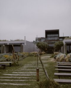A peaceful garden pathway at Areias do Seixo, lined with lush greenery leading towards the venue’s entrance.