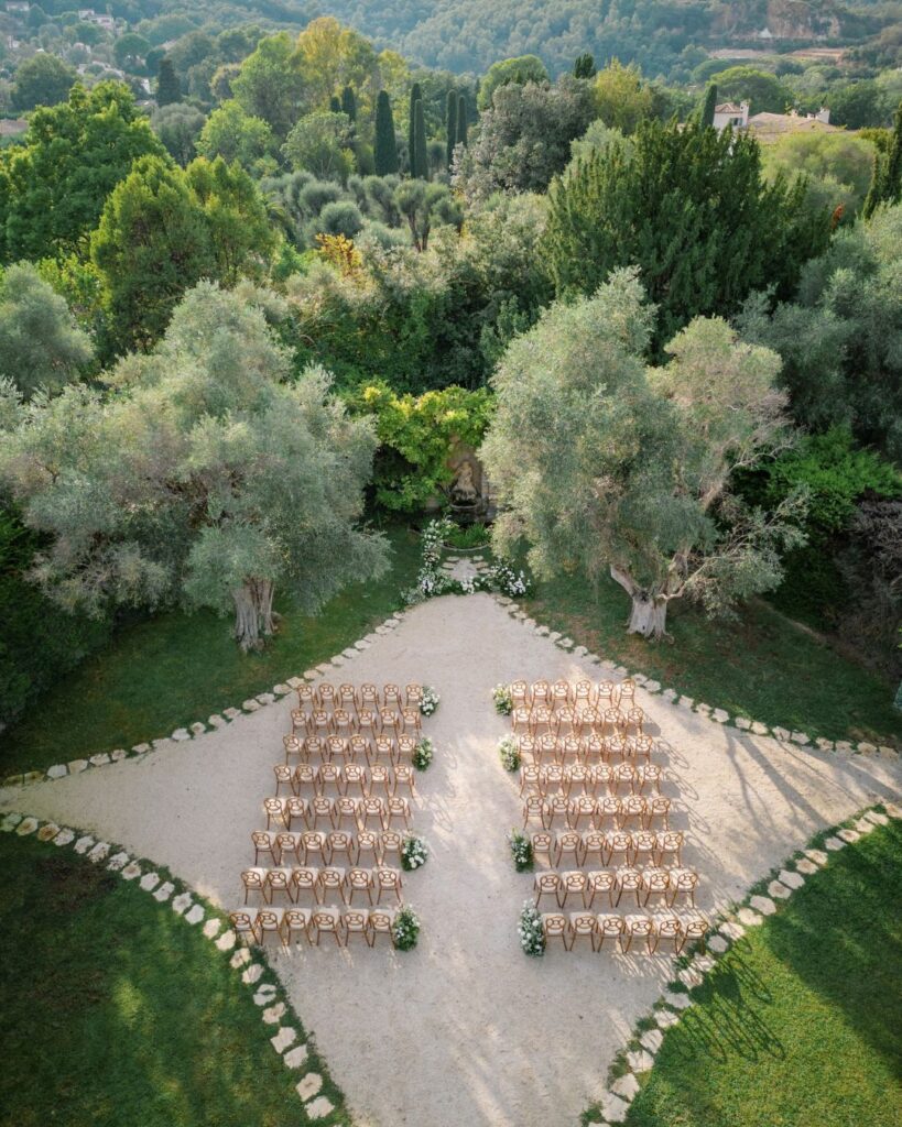 Scenic wedding ceremony setup at Bastide du Roy, featuring a historic stone fountain as the backdrop.
