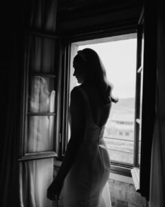 A quiet bridal moment, as she adjusts her veil in front of an antique mirror at Rosewood Castiglion del Bosco.