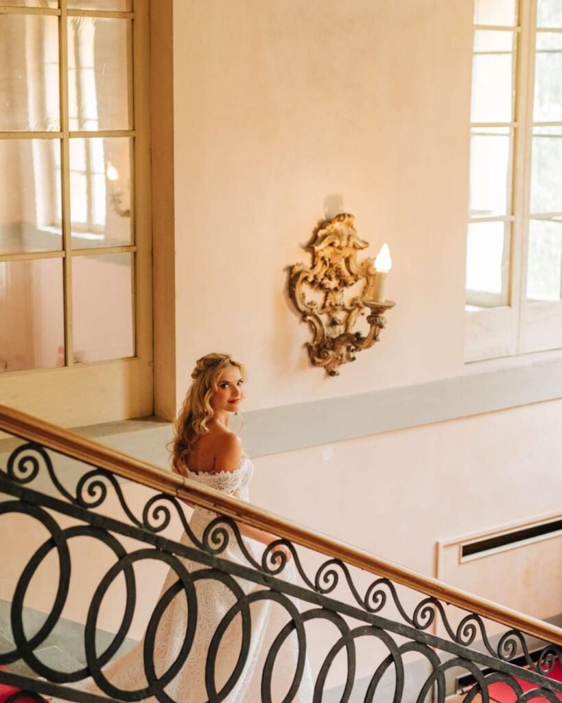 The bride descends the grand staircase at Villa Lungomonte, her dress flowing elegantly behind her.