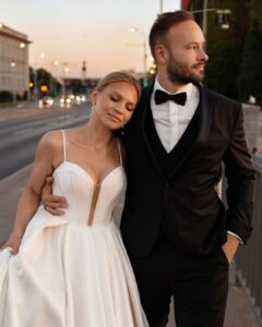 Romantic portrait of bride leaning gently on groom at sunset in a city setting, captured by Sylwia Zylka.