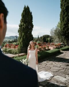 The couple walking along a picturesque cypress-lined pathway at Rosewood Castiglion del Bosco.