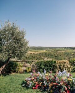 Elegant floral arrangements on the ground frame the wedding altar at Quercia al Poggio.
