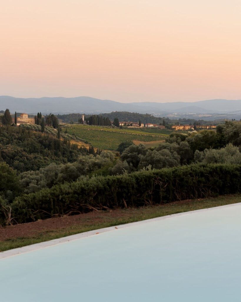 The crystal-clear pool at Quercia al Poggio reflects the surrounding Tuscan landscape in golden light.