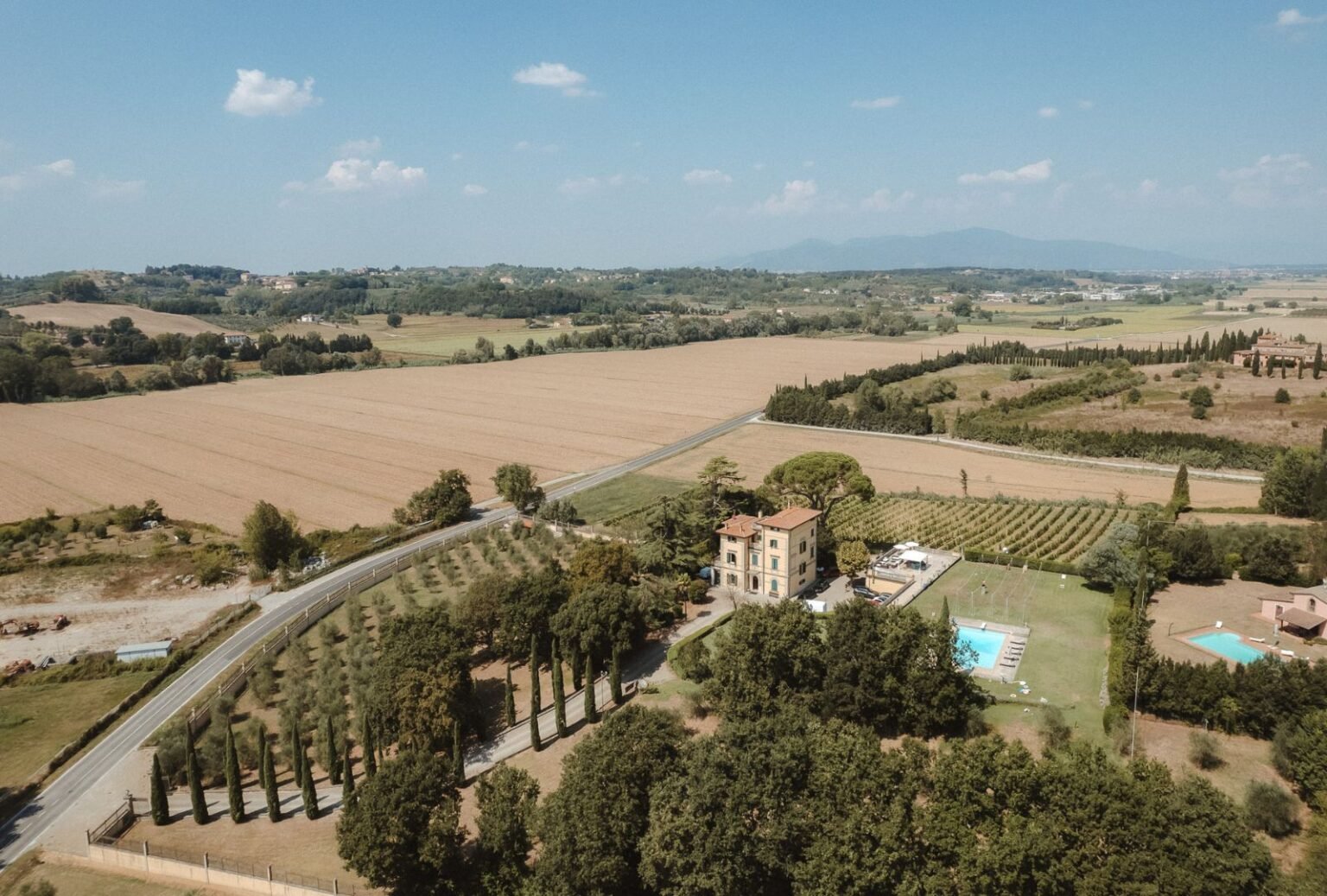 An aerial view of Villa Donna Camilla, showcasing its stunning architecture and green surroundings.