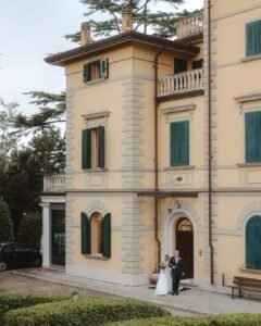 The grand entrance of Villa Donna Camilla, framed by historic architecture and lush greenery.
