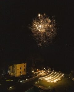A breathtaking aerial view of Villa Donna Camilla illuminated by a stunning fireworks display.