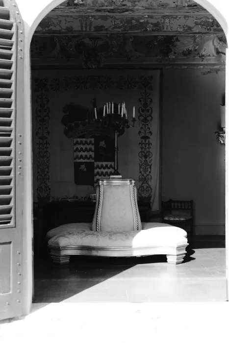 Ornate circular sofa with a candelabra centerpiece inside Borgo Stomennano’s historic interior