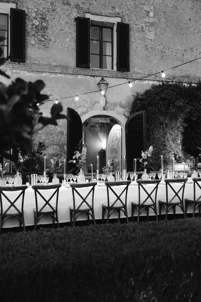 Wedding reception setup outside the stone villa at Borgo Stomennano under a canopy of string lights.