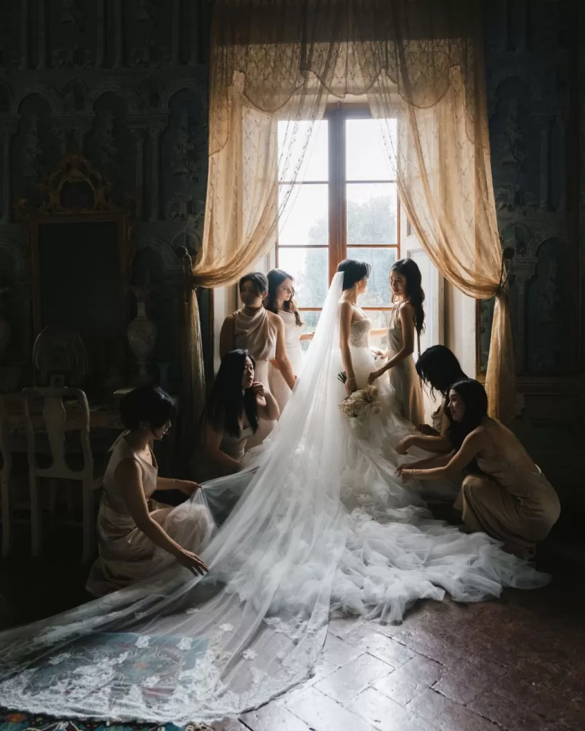 The bride shares a joyful moment with her bridesmaids in the elegant setting of Villa di Geggiano