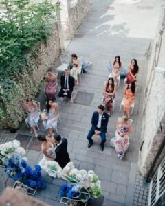 Aerial view of the wedding ceremony at Castello Montignano with guests seated along a narrow historic courtyard.