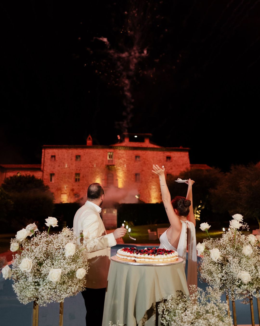 Wedding cake and fireworks celebration outside Castello Montignano at night