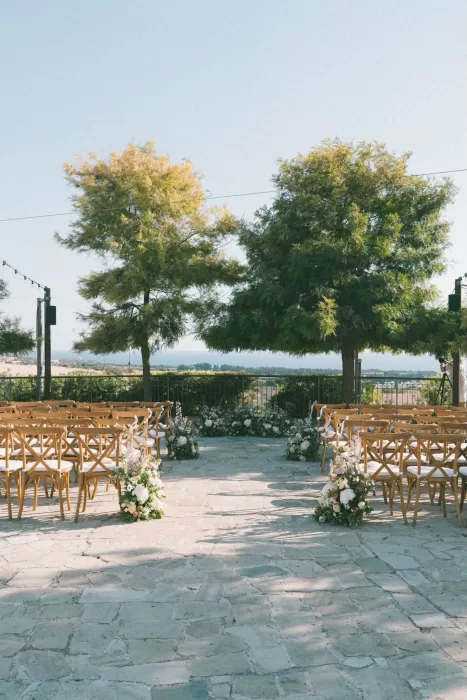Romantic outdoor ceremony setup with sea views and floral arrangements at Liopetro.