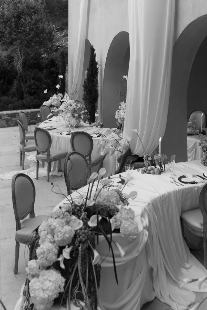 Outdoor courtyard wedding reception at Mas Torroella with curved table layout and soft neutral tones.