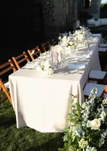 Elegant floral arrangements and lilac taper candles on wedding table at Mas Torroella.