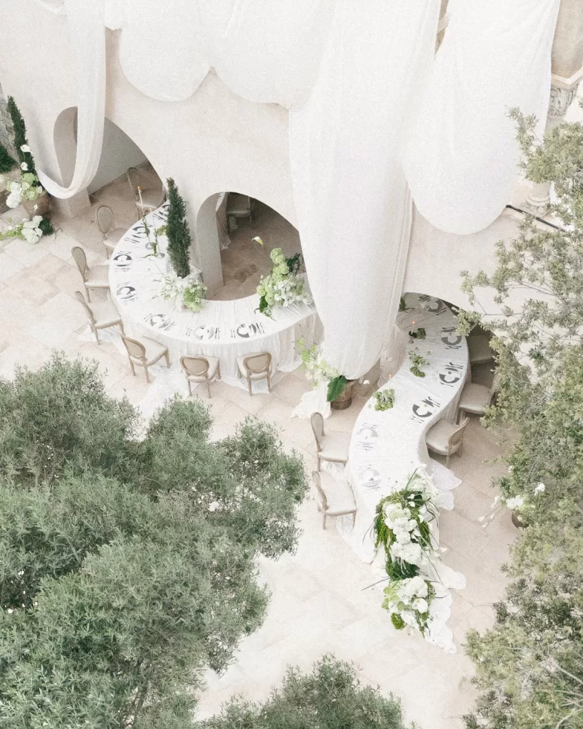 Elegant outdoor wedding setup at Mas Torroella showcasing arched architecture and neutral styling.