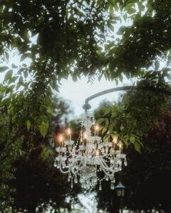 Crystal chandelier hanging among the trees for an enchanting outdoor wedding dinner at Villa Ivana.
