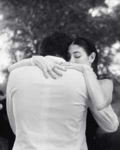 Intimate black and white moment as the bride holds her groom close during their first dance at Villa Ivana.