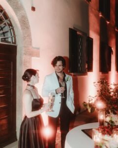 Romantic evening toast between the bride and groom under the warm glow of lights at Villa Ivana.