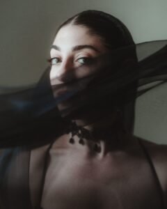 Striking bridal portrait with sheer black veil partially covering the bride’s face, captured in soft light at Villa Ivana.