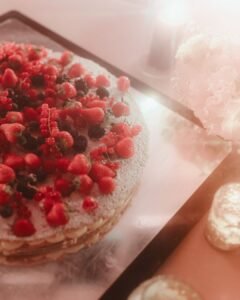 Close-up of a layered wedding cake covered in fresh berries, glowing under soft candlelight at Villa Ivana.