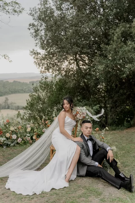 Romantic wedding portrait surrounded by wild floral arrangements overlooking the Tuscan countryside at Borgo Sant’Ambrogio.