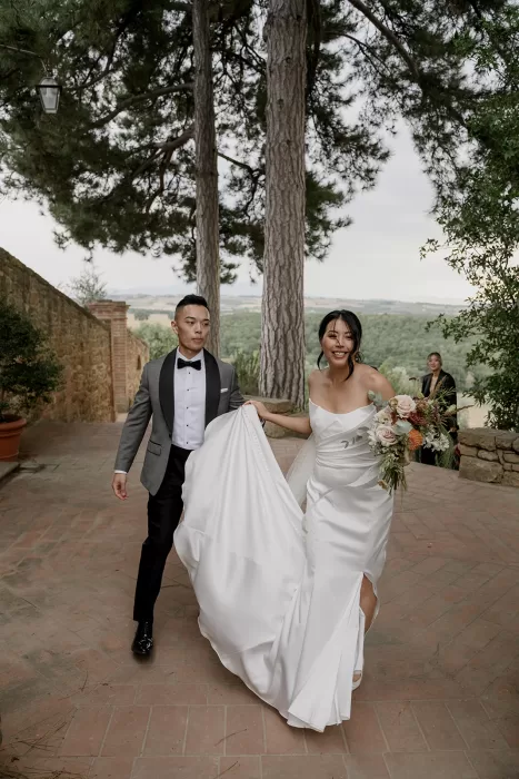 Bride and groom laugh and hold hands after the ceremony at Borgo Sant'Ambrogio