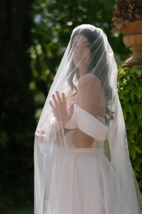 Artistic close-up of the bride under her veil at Tenuta Corbinaia, softly lit by dappled sunlight.