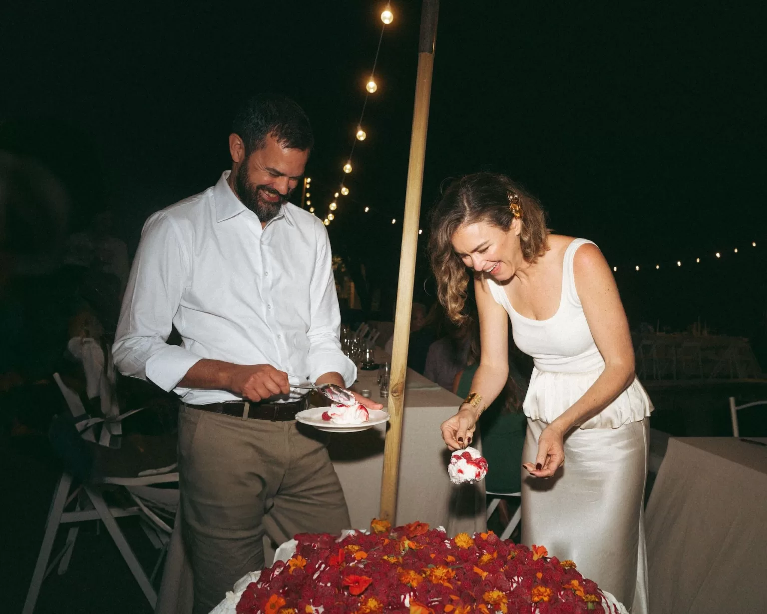 The couple cutting their wedding cake at Casa Sacoto, surrounded by candles and guests.