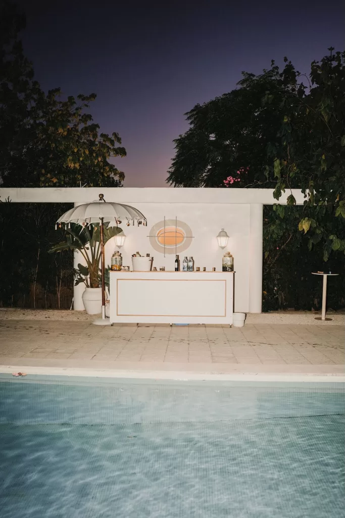 Poolside bar at Casa Sacoto set up for a wedding celebration, blending modern and rustic charm.