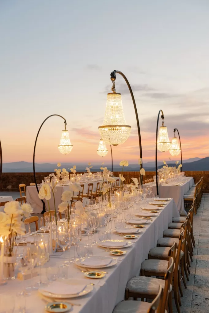 Elegant outdoor reception tables styled with white florals and chandeliers at Castello di Velona.