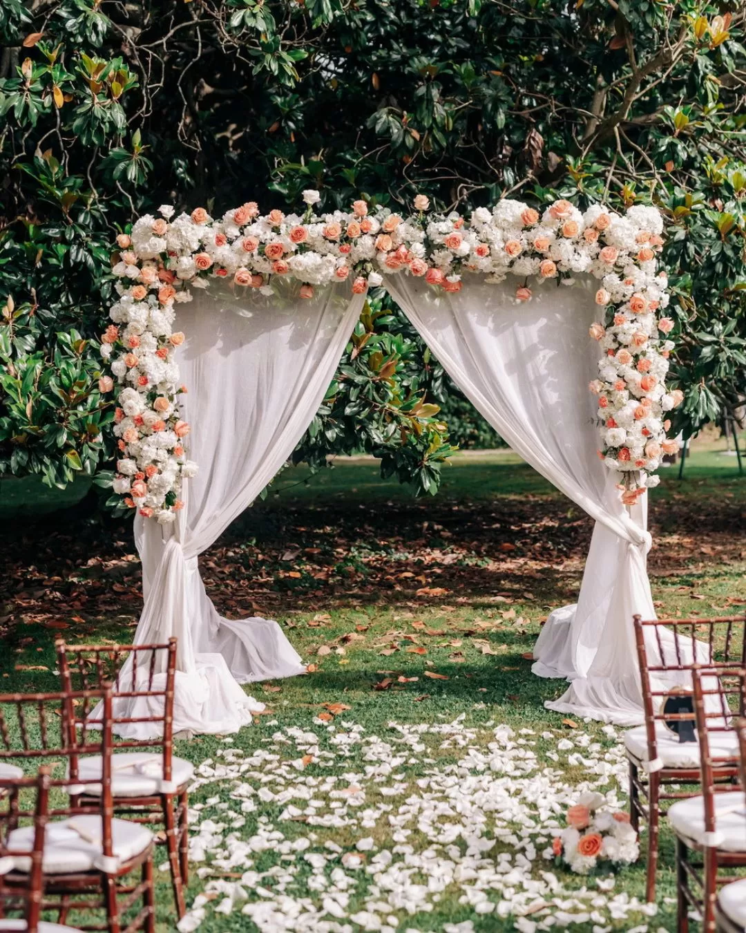 Lush floral arch set for an outdoor ceremony in the gardens of Villa Ravano