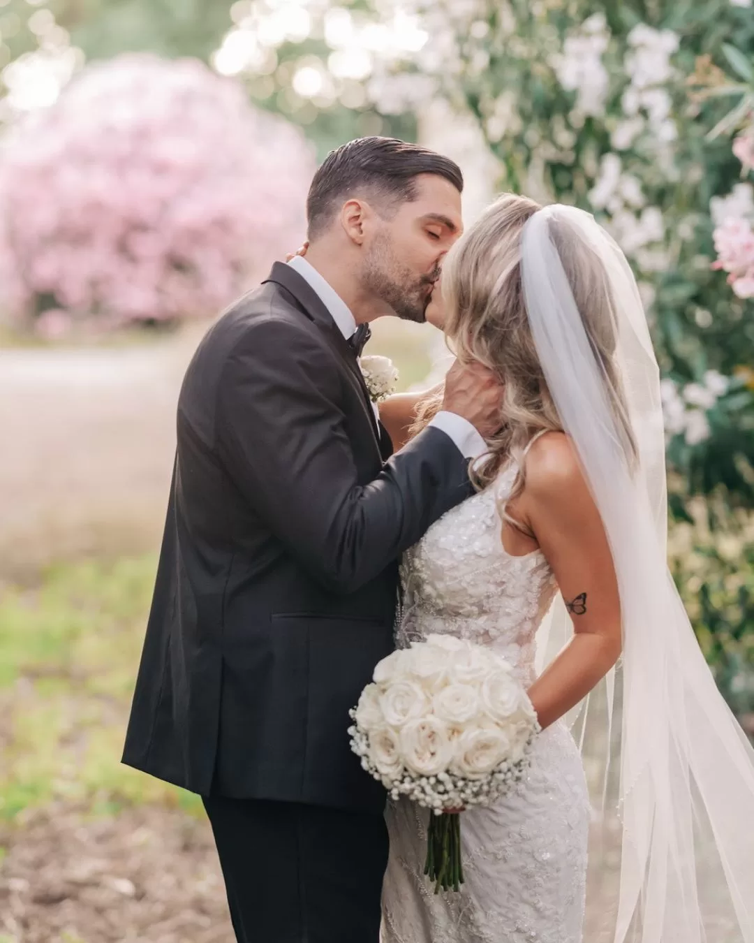 Newlyweds share a kiss in front of the historic façade of Villa Ravano