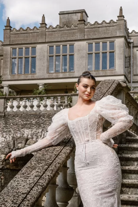 Close-up of the bride in a lace gown, leaning gracefully on the stone staircase at Euridge Manor.