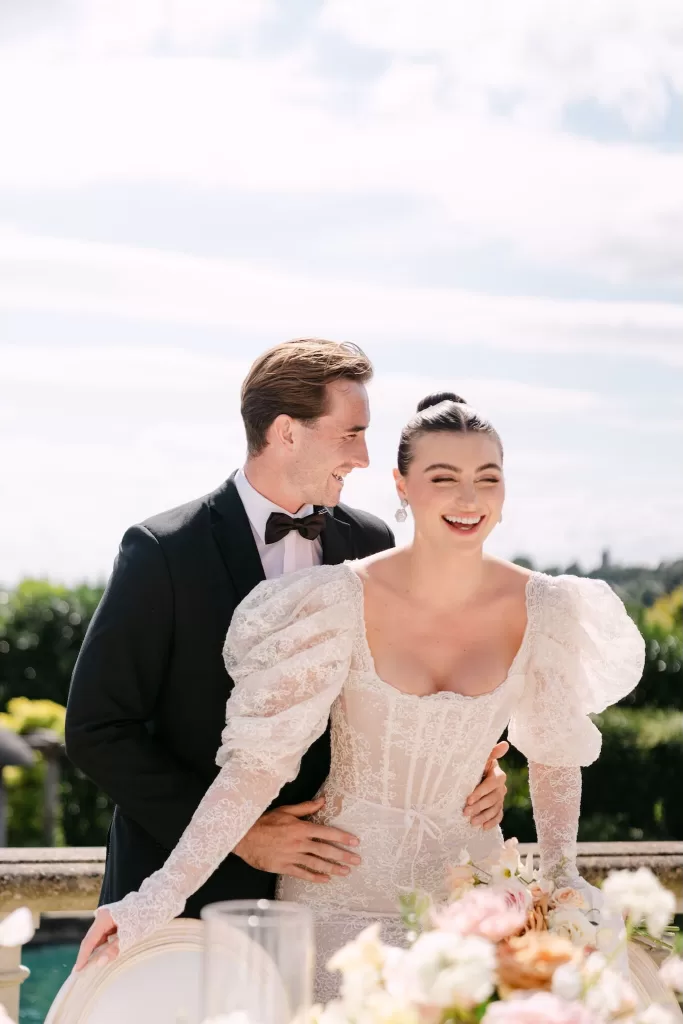 Joyful bride and groom sharing a laugh beside their floral wedding table at Euridge Manor.