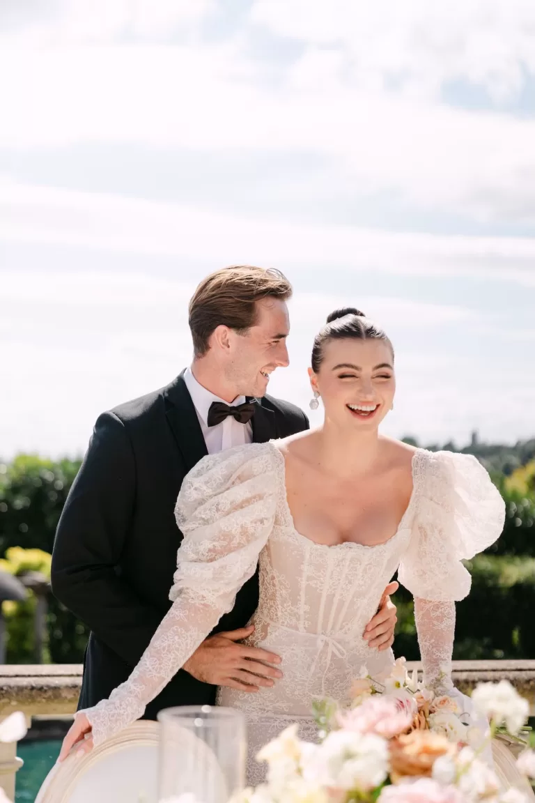 Joyful bride and groom sharing a laugh beside their floral wedding table at Euridge Manor.
