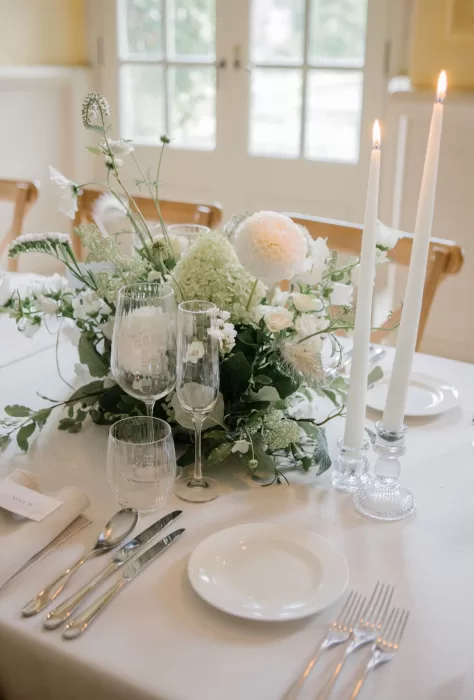 Elegant white flowers and glowing candles set the tone for a refined wedding table inside Euridge Manor.