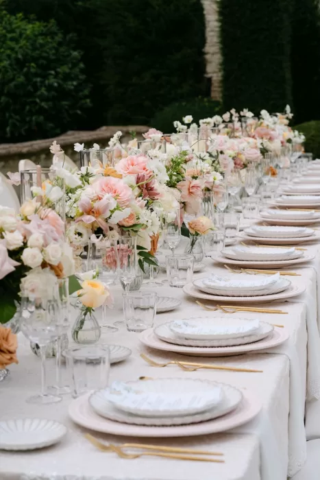 Elegant wedding table setting with layered plates, golden cutlery, and soft floral arrangements at Euridge Manor.