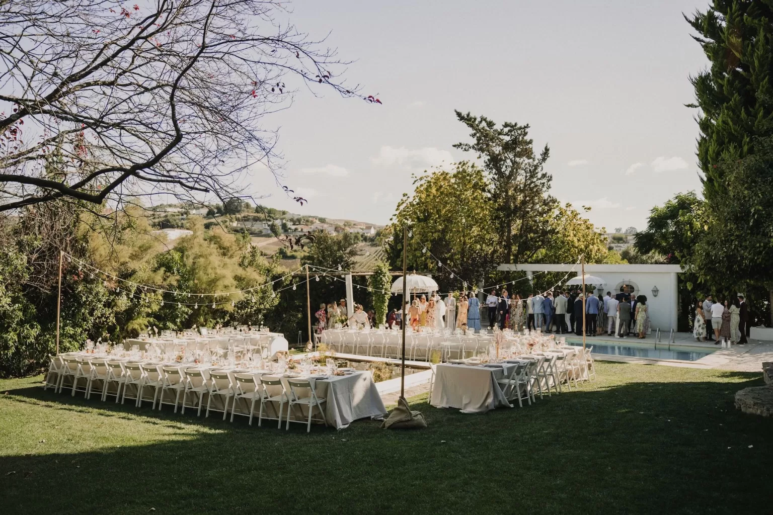 Garden reception setup with long tables and florals at Casa Sacoto in Portugal.